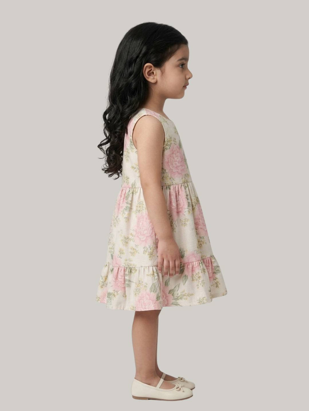 Cream floral sleeveless dress with soft ruffle hem detail.