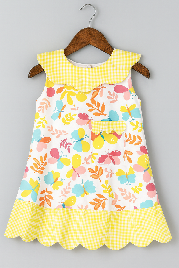 Colorful children's dress with floral pattern and yellow accents on a hanger against a gray background